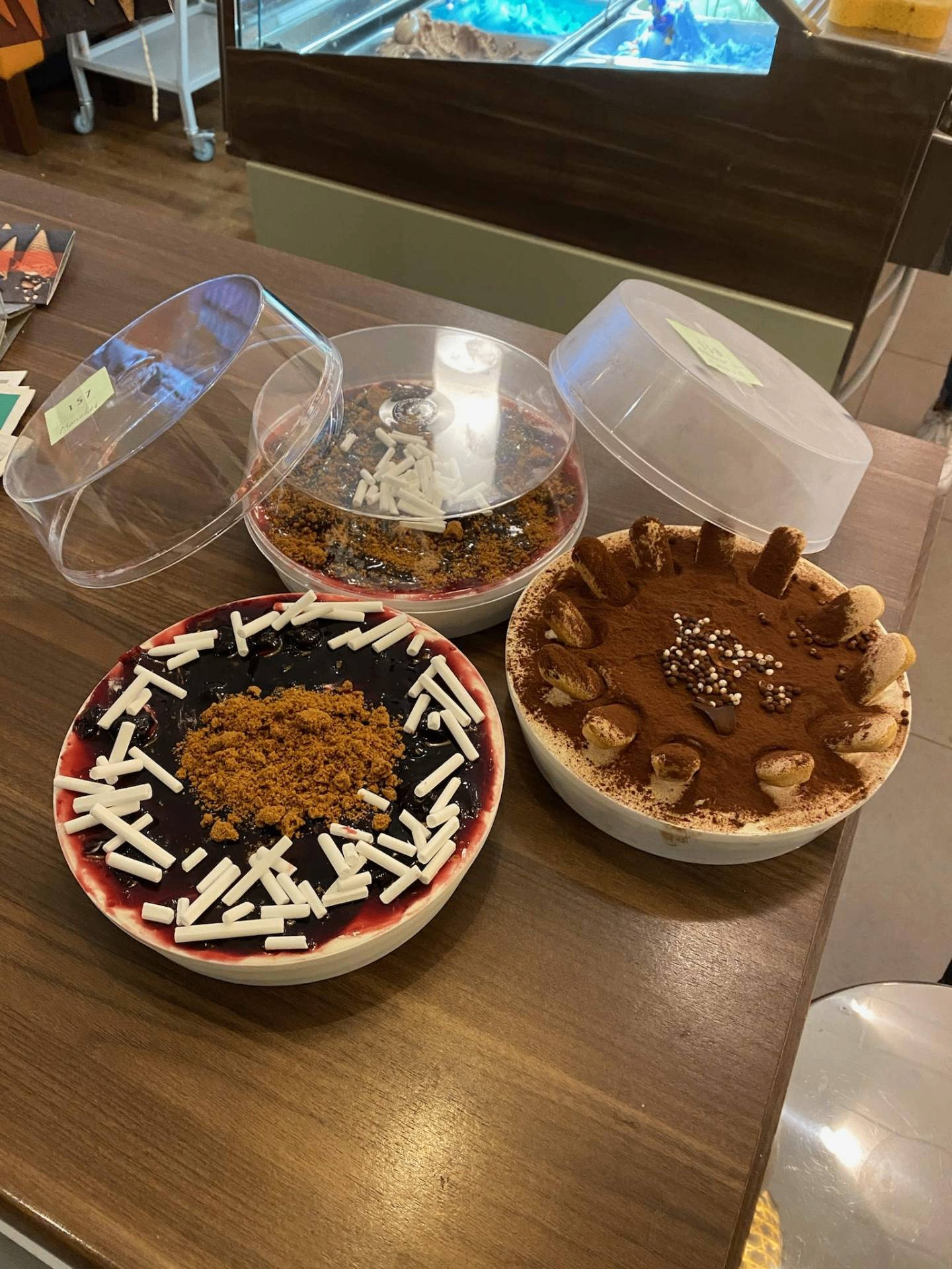 Drie verschillende ijstaarten, waaronder tiramisu en bosvruchten.